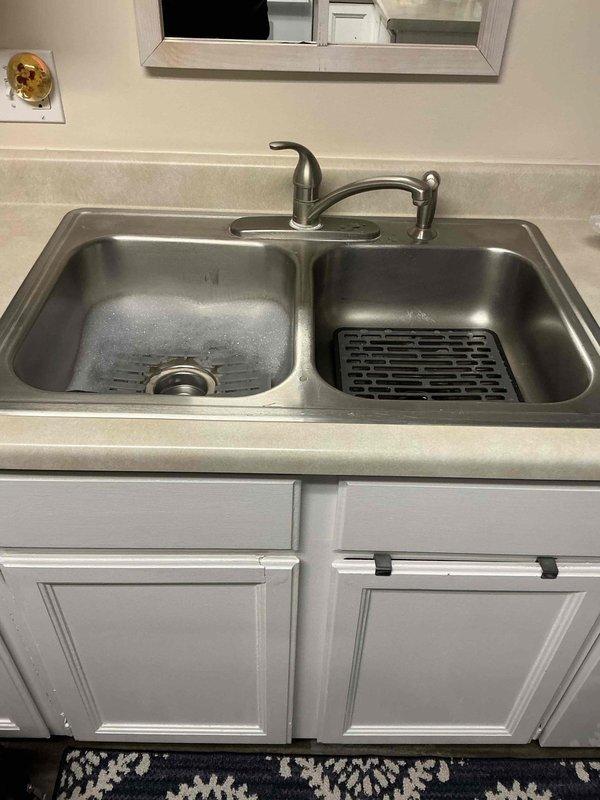 Completed customer-supplied center-set faucet installation in kitchen sink. Installed new supply lines and ensured proper drainage connections to existing PVC system under cabinet. All connections tested with no leaks observed.