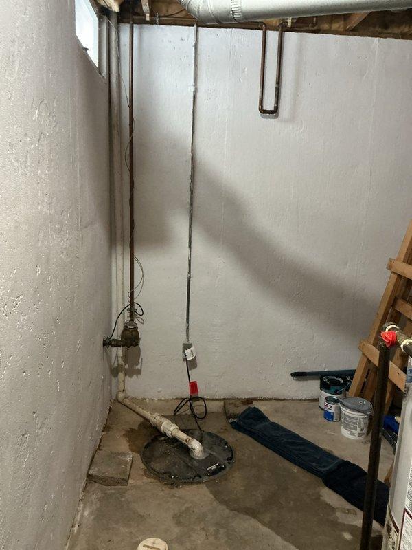 Diagnosed and serviced a non-functioning sump pump in basement. Sump pump was found in a concrete floor pit with PVC discharge piping. Observed moisture staining around pump area, indicating recent water presence, and restored system to proper working condition.