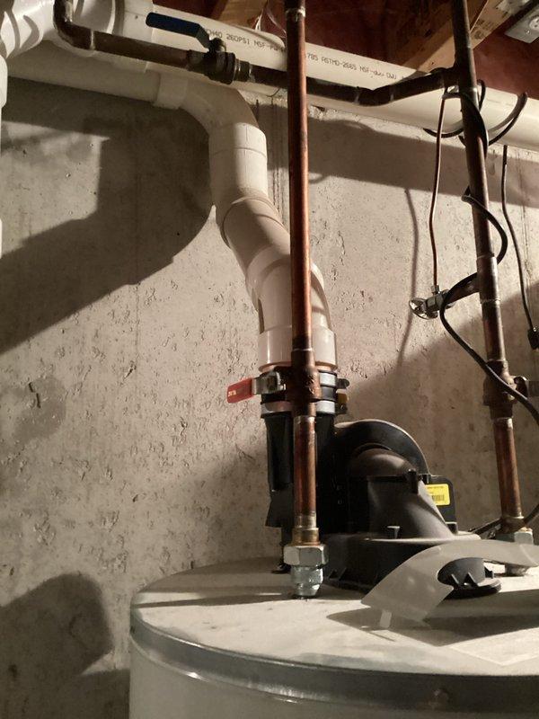 Responded to customer request for water heater estimate after existing unit leaked and was emptied. Conducted visual inspection of current installation, noting copper supply lines, PVC drainage connections, and existing plumbing configuration in basement utility area. Documented current setup with photos to prepare comprehensive replacement estimate.