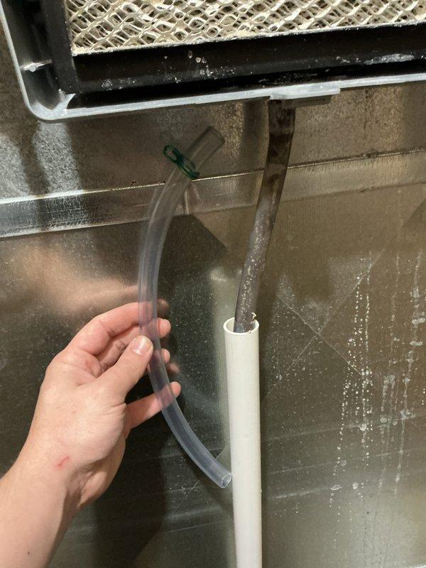 Performed annual heating maintenance on 12-year-old Goodman furnace. Discovered deteriorated condensate drain line with significant internal corrosion and mineral buildup. Replaced damaged section and cleared drainage system to restore proper condensate removal and prevent potential water damage.