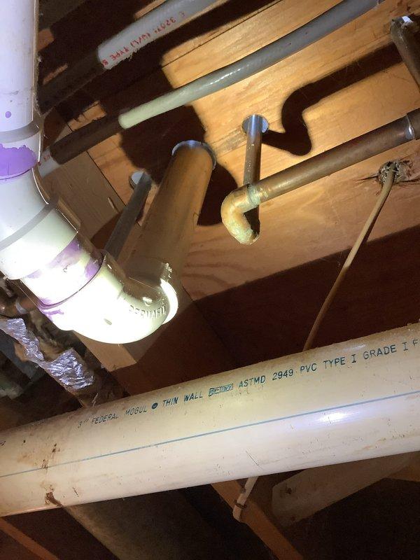 Relocated drain line and water supply for new vanity installation. Completed PVC waste line connections with proper primer/adhesive at joints and installed copper supply lines through existing joist framing. All connections were tested and verified to be leak-free upon completion.