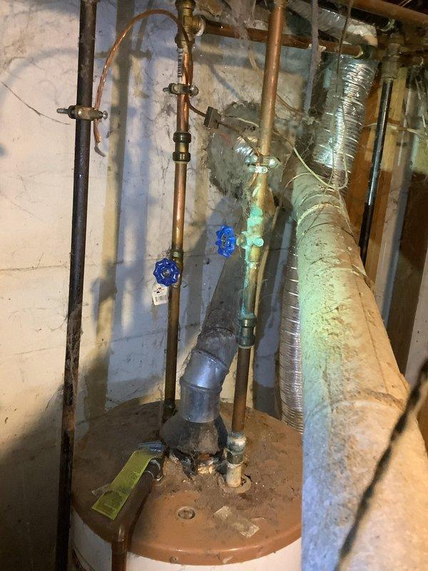 Completed estimate for water heater replacement in unfinished basement area. Inspection revealed aging copper supply lines with visible oxidation/corrosion at connections, multiple blue shutoff valves, and PVC drain piping with significant dust/cobweb accumulation. Current installation shows signs of inadequate maintenance and will require complete replacement of the existing unit along with possible plumbing updates to meet current code requirements.