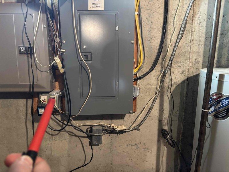 Conducted a water heater estimate in cramped utility area with visible electrical panel and deteriorated wooden components. Inspected existing electrical infrastructure including breaker panel and associated wiring. Documented conditions with photos for comprehensive assessment of installation requirements under CWOW reference 616-558-6379, CM 2017.