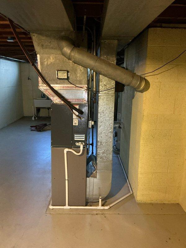 Conducted comprehensive assessment of existing HVAC system, including furnace and AC unit located in basement utility room. Documented current installation configuration (furnace with PVC venting, round metal ductwork) and evaluated cooling performance issue regarding insufficient cold air output from AC. Provided estimate for furnace and AC replacement options and discussed Nest thermostat installation requirements with customer.