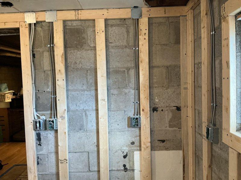 Completed electrical installation for kitchen remodel project, installing four new circuits and four recessed disc lights. Work involved running electrical conduit through existing concrete block walls with wood framing, mounting junction boxes at standard heights, and connecting all necessary wiring for the renovation.