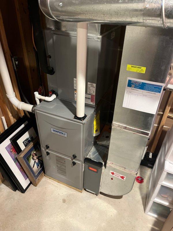 Completed annual tune-up on 8-year-old ICP furnace as part of Comfort Club membership. Inspected TempStar system components including connections, PVC venting, and ductwork, all functioning properly. Documented system condition with photos of the furnace installation and surrounding utility area.