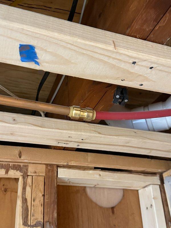 Replaced deteriorated connection lines on 2-year-old Navien boiler system. Work included removing damaged brass fittings and installing new copper-to-flex line connections secured through wooden joists. System was tested for proper operation and leaks after installation.
