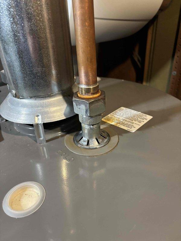 Responded to water heater leak service call. Inspection revealed corrosion at copper pipe connection to tank fitting, with visible oxidation at the joint. Replaced damaged connection components to resolve active leak.