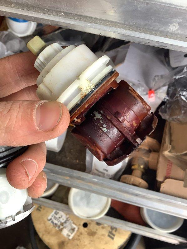 Diagnosed and repaired shower pressure regulator issue by disassembling valve assembly, removing calcium deposits from pressure balancing cartridge, and reassembling fixture. Tested shower operation to confirm proper water pressure regulation and smooth handle operation.