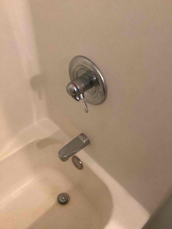 Diagnosed and repaired shower pressure regulator issue by disassembling valve assembly, removing calcium deposits from pressure balancing cartridge, and reassembling fixture. Tested shower operation to confirm proper water pressure regulation and smooth handle operation.