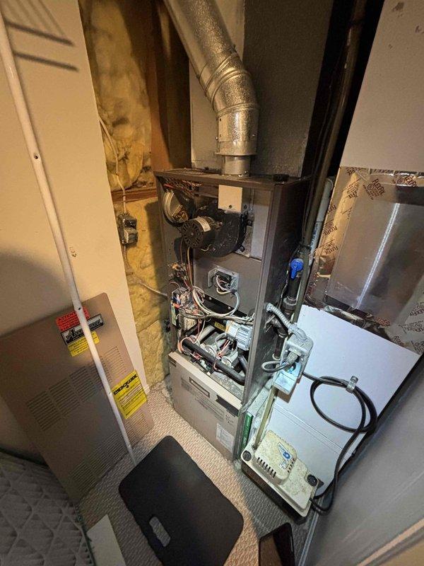 Performed complimentary annual tune-up on 16-year-old furnace. Removed front access panel for thorough inspection of internal components including control boards, wiring connections, and mechanical elements. Examined ductwork and connections, with particular attention to the visible elbow joint and surrounding insulation.