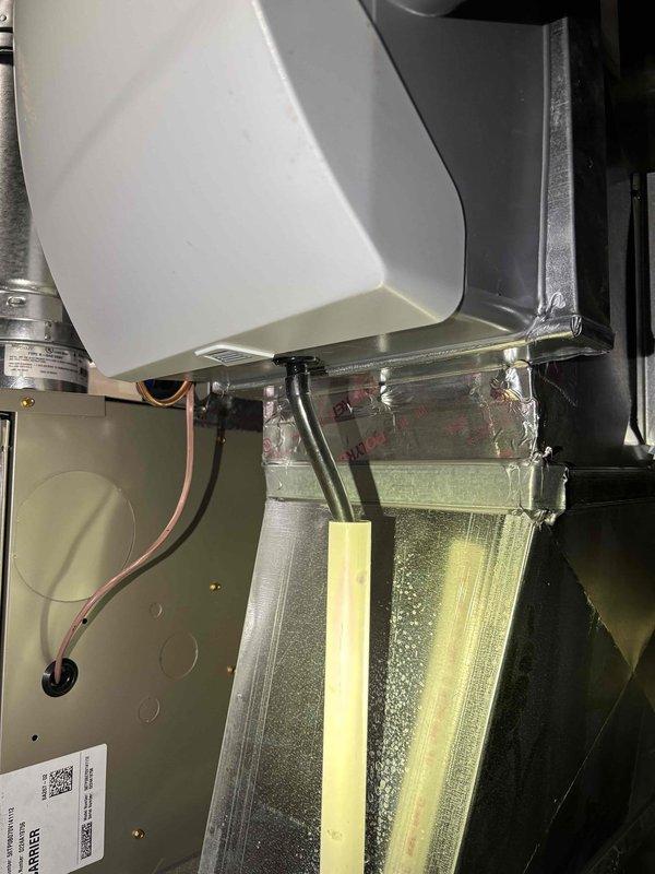 Responded to water leak service call for 1-year-old Carrier furnace. Discovered condensate drain line was clogged, causing water to pool on concrete floor beneath unit. Cleared blockage, cleaned drain assembly, and verified proper drainage function. System is now operating correctly with no signs of leakage.