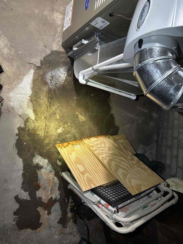 Responded to water leak service call for 1-year-old Carrier furnace. Discovered condensate drain line was clogged, causing water to pool on concrete floor beneath unit. Cleared blockage, cleaned drain assembly, and verified proper drainage function. System is now operating correctly with no signs of leakage.