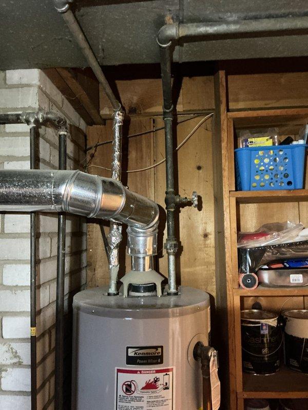 Performed annual heating maintenance on 13-year-old Goodman furnace and humidifier. Inspected water heater as requested by customer, noting significant deterioration and recommending replacement. Examined ductwork connections and venting system, confirming proper installation despite minor wall discoloration around vent penetrations.