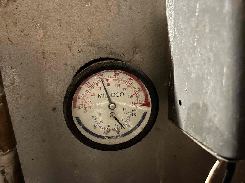Responded to radiator leak in 20-year-old boiler system. Inspection revealed severe corrosion at copper pipe connection point with compromised integrity. Pressure gauge reading was abnormally low, indicating system pressure issues contributing to the leak. Replaced damaged pipe section and installed new connection fitting to restore proper system operation.