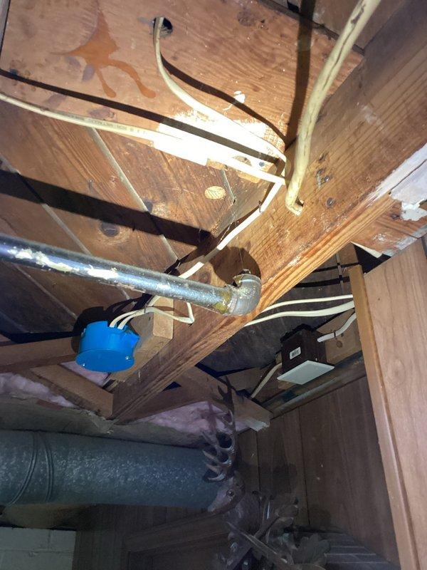 Conducted a comprehensive inspection of a 75-year-old residential property to assess gas line installation requirements. Examined exposed structural areas including wooden joists, existing plumbing infrastructure, and electrical systems. Documented multiple utility pathways and identified potential installation routes for new gas line, noting some water damage to wooden structural elements and the presence of both galvanized metal piping and PVC components that will require integration with the proposed gas system.