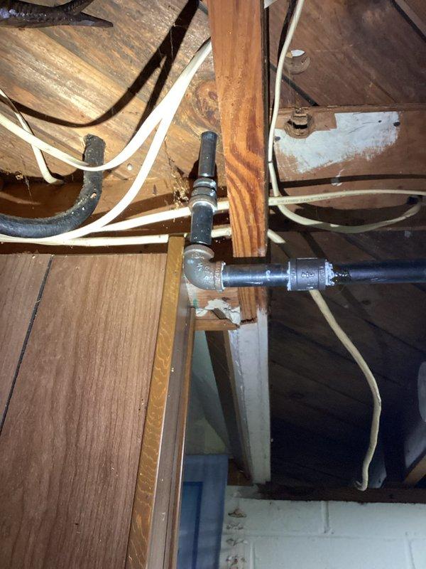 Conducted a comprehensive inspection of a 75-year-old residential property to assess gas line installation requirements. Examined exposed structural areas including wooden joists, existing plumbing infrastructure, and electrical systems. Documented multiple utility pathways and identified potential installation routes for new gas line, noting some water damage to wooden structural elements and the presence of both galvanized metal piping and PVC components that will require integration with the proposed gas system.