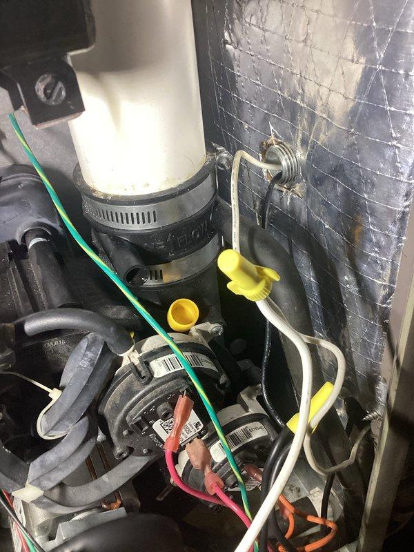Responded to service call for 12-year-old York furnace that stops working at night. Inspection revealed significant condensate leak with water pooling on concrete floor around unit. Identified and repaired failed condensate drainage system, replacing damaged PVC pipe connections and securing with new hose clamps to prevent future leakage issues.