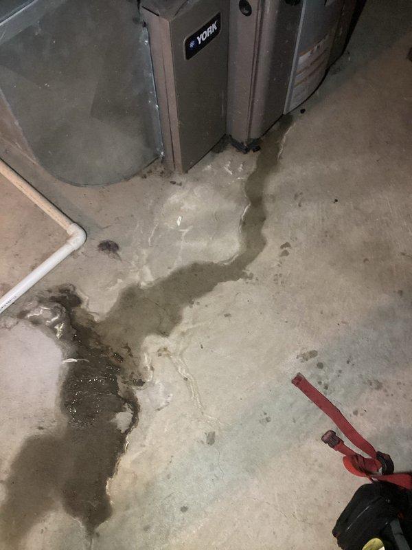 Responded to service call for 12-year-old York furnace that stops working at night. Inspection revealed significant condensate leak with water pooling on concrete floor around unit. Identified and repaired failed condensate drainage system, replacing damaged PVC pipe connections and securing with new hose clamps to prevent future leakage issues.