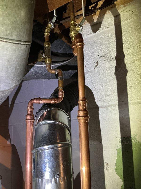 Successfully installed a 40-gallon natural gas water heater (ND 10/10 tall model) in basement utility area. Removed existing utility sink as requested. Ensured proper connection of copper supply lines with appropriate valves and fittings, and verified sump pump drainage system was unaffected by the installation.