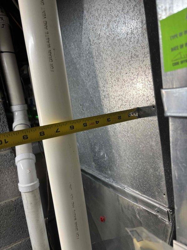 Completed annual heating system maintenance on furnace per ENE 5-year warranty requirements. Inspected and measured PVC exhaust piping, confirming proper installation dimensions at approximately 9-10 inches and 13-14 inches at connection points. System is operating within manufacturer specifications.