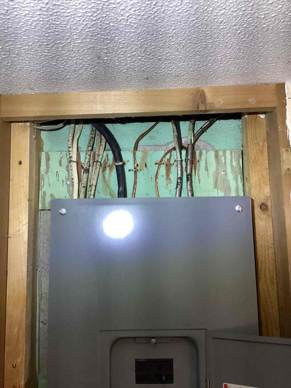 Conducted comprehensive estimate for furnace, water heater, and AC replacement. Inspected electrical panel and observed water damage around utility access area with moisture staining on insulation. All systems currently operational; photos documented existing conditions for proper replacement specifications.