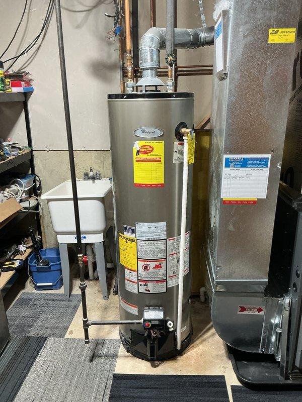Completed estimate for replacement of 18-year-old Whirlpool water heater with new 40-gallon tank water heater. Quote includes complete installation service with removal of existing unit. Documented current installation configuration with photos showing proper ventilation, plumbing connections, and electrical components in utility area of 25-year-old home.