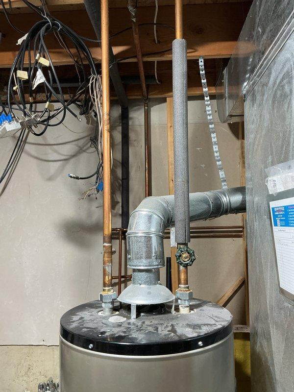 Completed estimate for replacement of 18-year-old Whirlpool water heater with new 40-gallon tank water heater. Quote includes complete installation service with removal of existing unit. Documented current installation configuration with photos showing proper ventilation, plumbing connections, and electrical components in utility area of 25-year-old home.