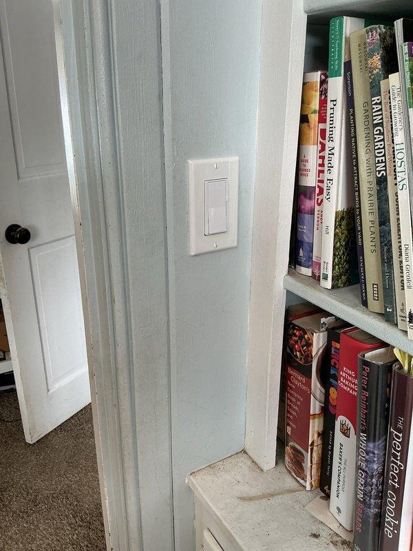 Relocated electrical outlet per customer request in residential setting. Worked with existing outlet positioned near bookshelf area, moving it to the specified location on navy blue wall. Completed installation with proper mounting and verified functionality after relocation.