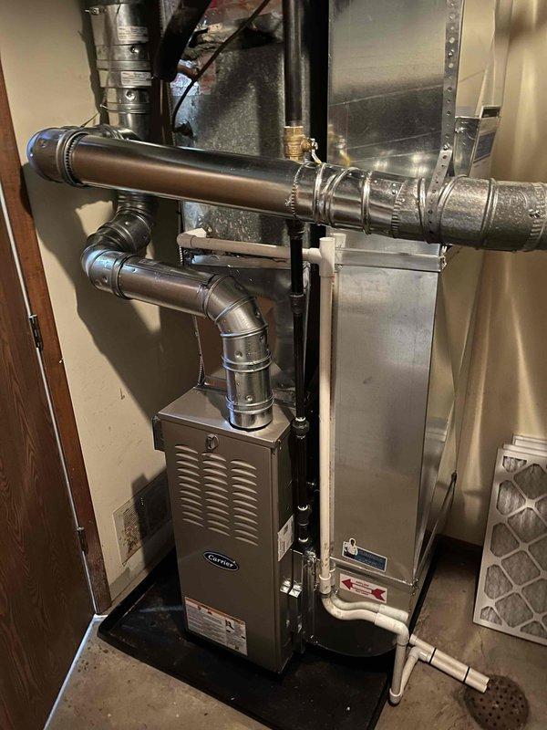 Successfully installed a new Carrier furnace unit with complete ductwork connection system. Installed all required ventilation components including horizontal and vertical metal ducts with proper insulation and secure fastening. System was tested and confirmed to be in good working condition.