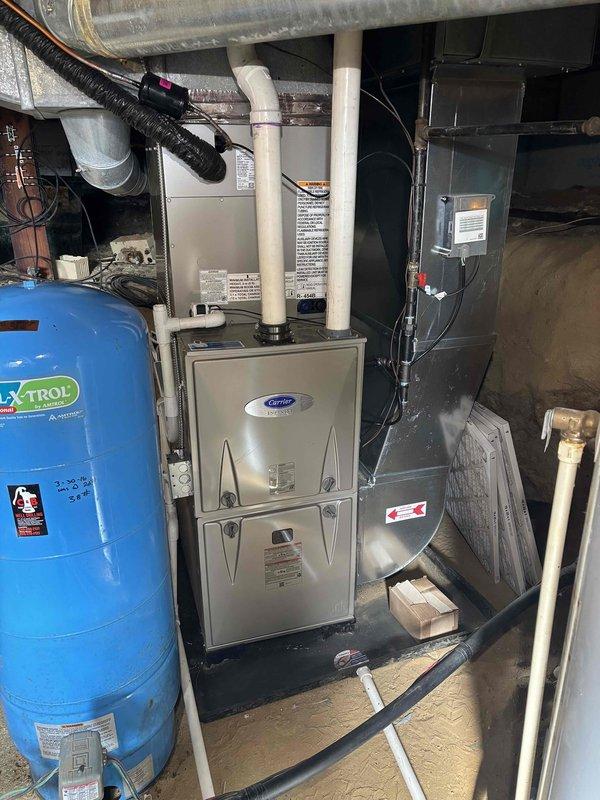 Successfully completed installation of new Carrier furnace system with dual PVC exhaust venting and accompanying outdoor AC condenser unit. The furnace was properly connected to existing ductwork with all necessary electrical components installed to manufacturer specifications. Exterior condenser was positioned on concrete pad with appropriate clearance for optimal airflow and connected to the home's electrical system via disconnect switch.