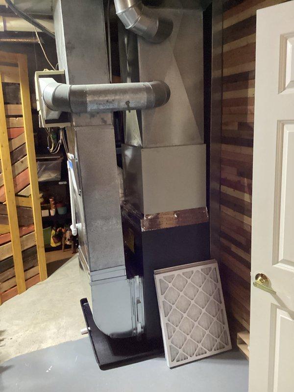 Successfully completed furnace installation in basement utility area, installing new Energy brand furnace unit with proper PVC ventilation system and ductwork connections. System was mounted on platform with all electrical connections properly secured, and new air filter was provided to customer.