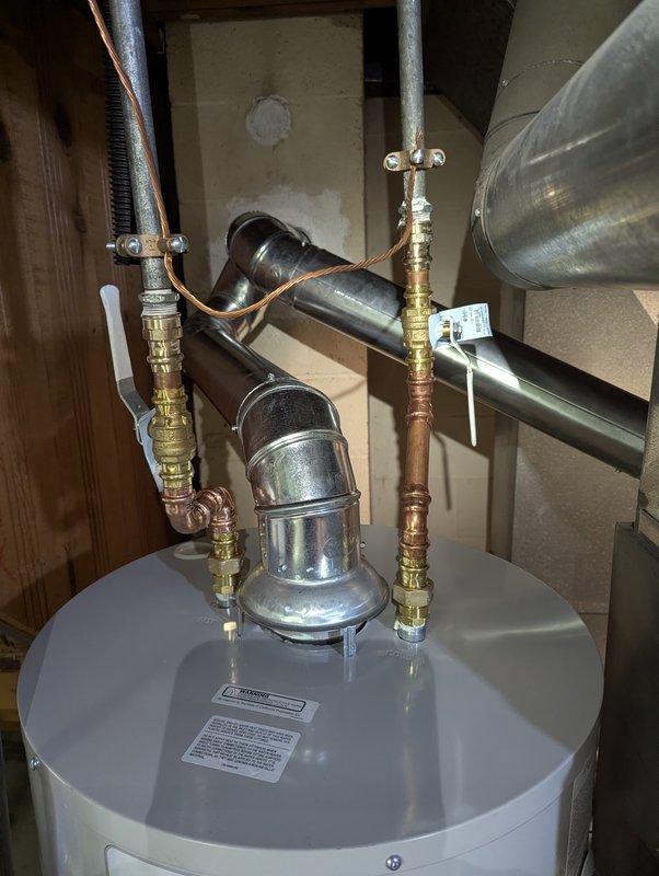 Successfully installed a 40-gallon natural gas water heater with short configuration. Connected all necessary copper supply lines with appropriate brass fittings and installed proper ventilation ductwork with metal clamps to ensure safe operation. Verified all connections were secure and system was functioning correctly before completion.