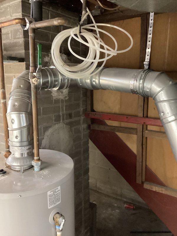 Conducted on-site water heater estimate for replacement of 40-gallon tank unit showing active leakage and rust deterioration at bottom. Documented existing installation with photos showing current water heater setup and HVAC placement in utility area with PEX connections and surrounding ductwork to assist with proper replacement specifications.