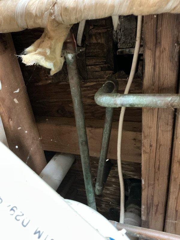 Conducted inspection of 1950s residential bathroom requiring replacement of outdated two-stem shower faucet with modern single valve system. Documented significant water damage to wall tiles and underlying structure, with visible deterioration at tile-floor junction and evidence of moisture penetration. Estimate prepared for complete valve replacement including necessary tile cutting, installation of remodel plate, and addressing associated water damage in the confined plumbing access area.