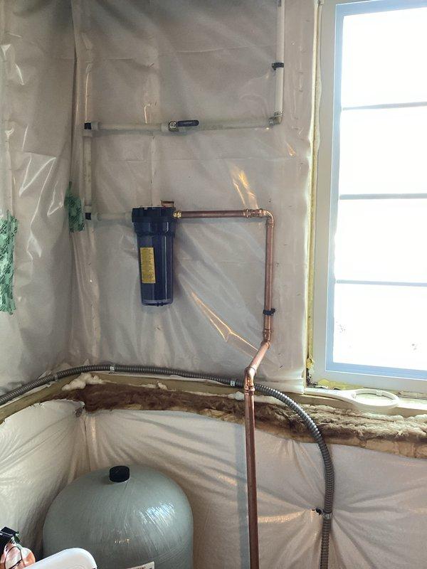 Completed installation of carbon filter system with copper pipe connections and replaced electric anode rod in water heater. Set up temporary electrical outlet with surge protection to power water treatment equipment. All systems tested and functioning properly.