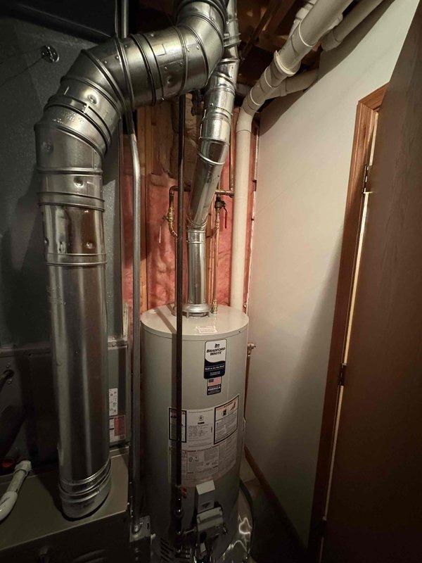 Completed installation of new Carrier furnace and water heater in residential mechanical room. System includes proper ductwork connections with galvanized metal venting, PVC piping, and all required safety components. Both units are functioning properly with no issues observed during final inspection; customer financing is pending.