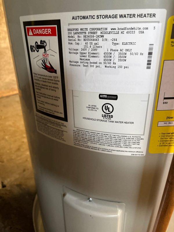 Successfully completed installation of a Bradford White 40-gallon electric water heater (240V/208V) in utility area. Unit was properly secured with copper supply lines connected to top ports using brass fittings, and installed on a metal drain pan for leak protection. All connections were verified and system tested for proper operation according to manufacturer specifications.