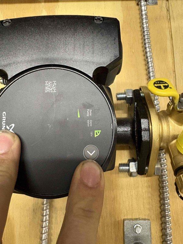 Responded to no heat complaint in bathroom with zoned Navien boiler system. Inspected Grundfos circulation pump and verified proper operation. Electrical testing with UEI DL379 meter showed 10.7 amp draw on pump, within normal parameters. Adjusted zone valve and bled air from system to restore proper heat flow to bathroom zone.