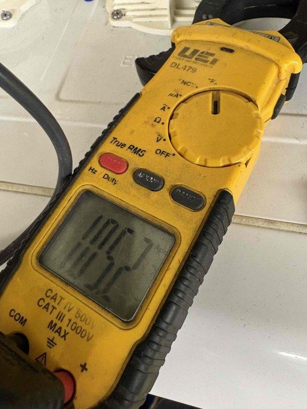 Responded to no heat complaint in bathroom with zoned Navien boiler system. Inspected Grundfos circulation pump and verified proper operation. Electrical testing with UEI DL379 meter showed 10.7 amp draw on pump, within normal parameters. Adjusted zone valve and bled air from system to restore proper heat flow to bathroom zone.