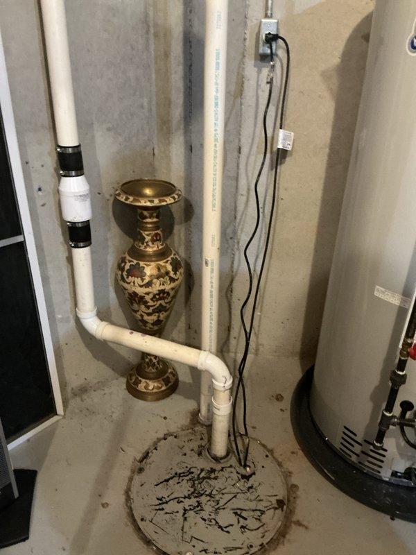 Successfully installed a sewage ejector pump in basement utility area to resolve existing drainage issue. Connected pump to PVC drainage system with proper elbow joints, ensuring connection to the floor drain. System is now operational with all electrical components properly connected and secured.