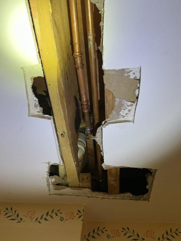 Responded to customer-reported water leak near previous repair site. Upon inspection, discovered active leak from copper supply lines in ceiling requiring access through drywall. Repaired compromised soldered joint in copper piping and verified system integrity with pressure test before closing.