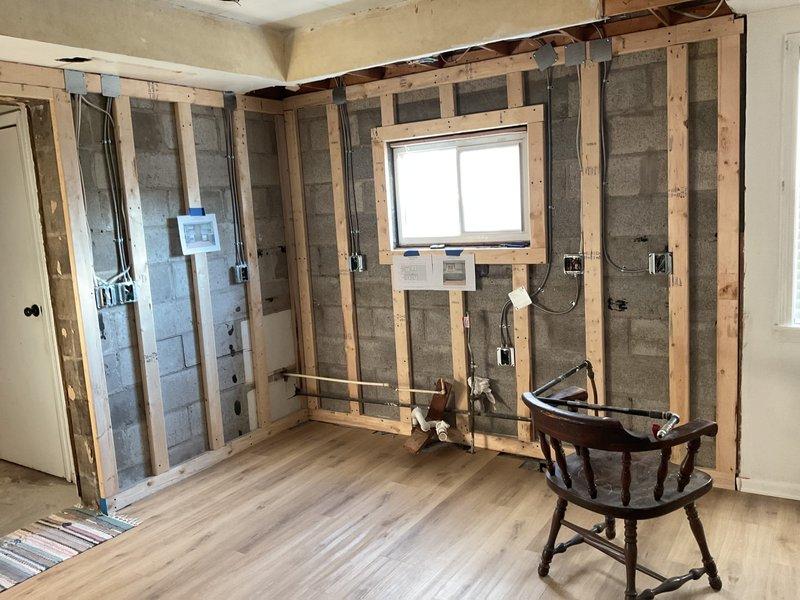 Completed kitchen plumbing rough-in work for renovation project, installing copper and PVC supply lines through floor. Positioned and secured piping according to project specifications, ensuring proper placement for future fixture installation in the concrete block wall construction area.