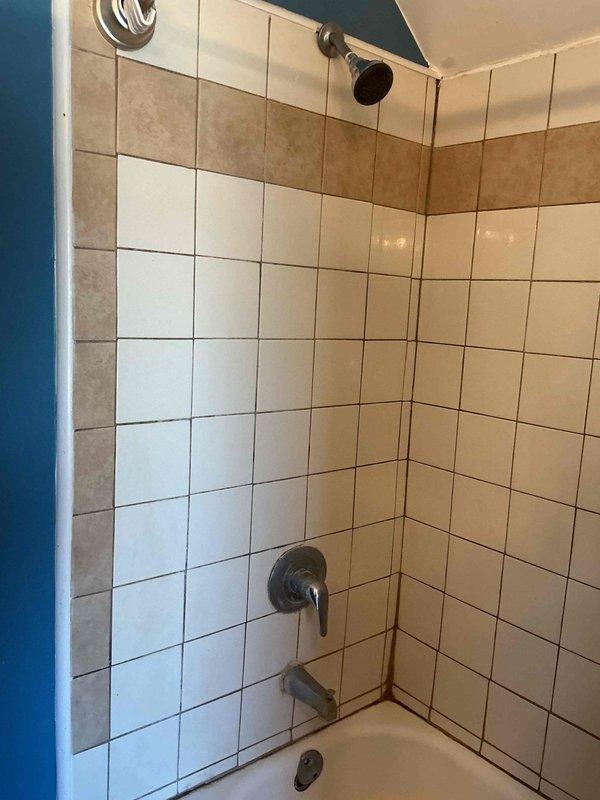 Responded to service call for low hot water pressure in tub/shower fixture. Accessed wall cavity behind shower controls to inspect plumbing system, revealing a malfunctioning four-way diverter valve with blue PEX supply lines and copper pipe connections. Successfully replaced the faulty valve assembly, restoring proper hot water pressure to the shower system.