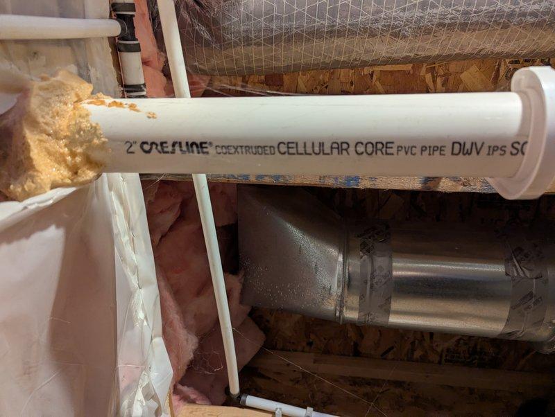 Responded to service call for 10-year-old Lochinvar water heater with ignition failure and flashing flammable vapor code on control unit. Inspected plumbing infrastructure and PVC drainage components in utility area. Documented condition with photos showing water heating system and associated piping.