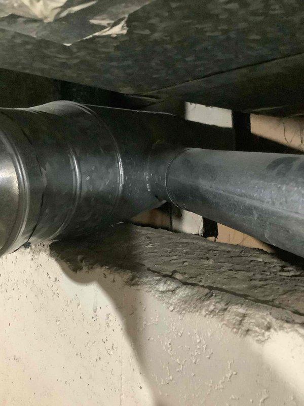 Conducted assessment of 10-year-old water heater showing multiple failure indicators including tank connection corrosion, audible popping noises, and deteriorated piping. Documented existing installation with photographs, focusing on surrounding ductwork and access constraints. Client agreed replacement is necessary rather than repair; estimate provided for complete water heater replacement.