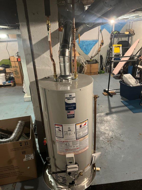 Completed installation of new Bradford White water heater and Energi furnace with associated ductwork in basement utility area. Systems were properly connected with appropriate copper supply lines, PVC venting, and drain pan placement. All components were tested and confirmed to be in normal working condition with no leaks or abnormalities.