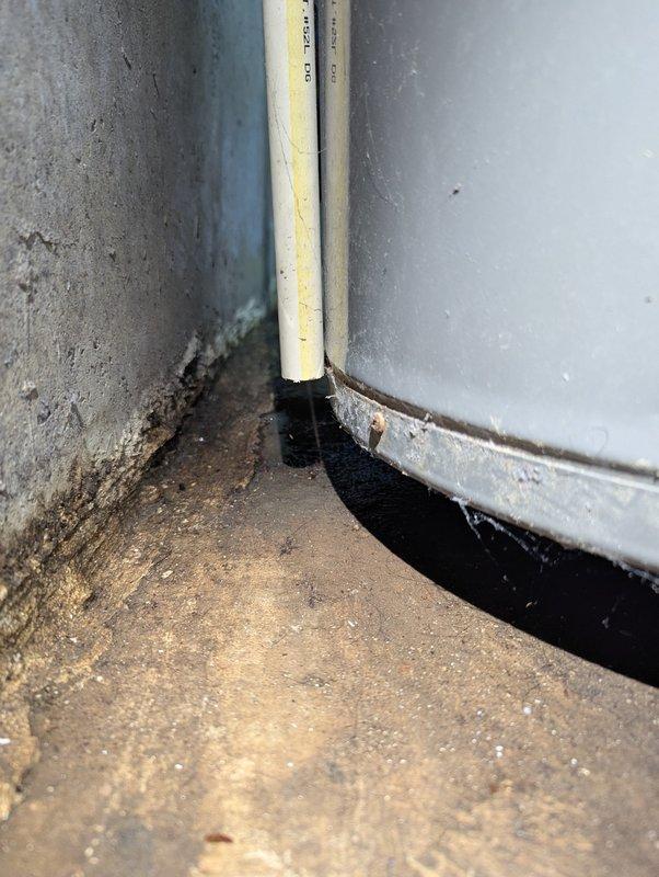 Responded to service call for 12-year-old water heater not producing hot water. Upon inspection, found significant corrosion at tank base and evidence of moisture damage/mold at installation point. Determined unit had reached end of useful life due to tank deterioration and recommended replacement.