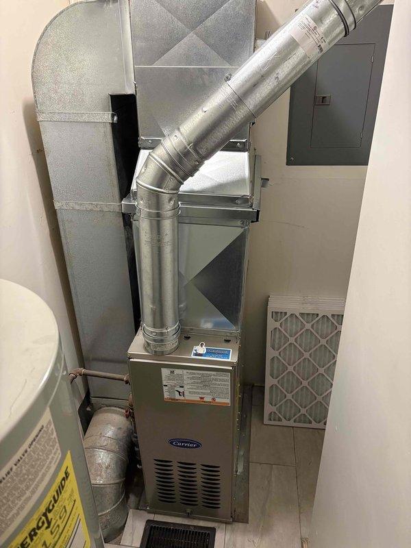 Successfully installed new Carrier furnace with complete ductwork integration, including proper connection to existing ventilation system and electrical panel. Unit was professionally mounted in utility area with filter housing accessible for maintenance, and all connections were verified for optimal system performance.