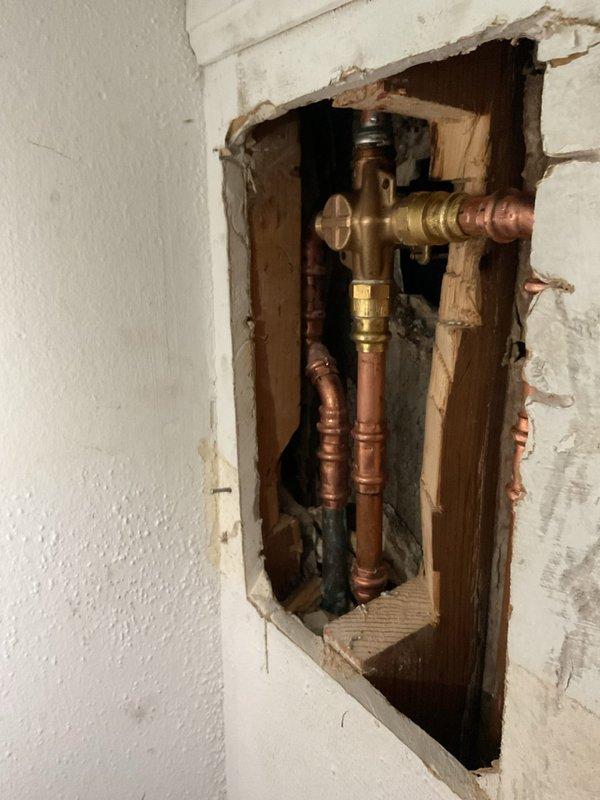 Successfully completed quoted shower valve/trim replacement requiring creation of drywall access point to expose existing plumbing. Removed damaged brass valve assembly, installed new fixture with proper copper pipe connections, and ensured system functionality with no leaks before closing access point.